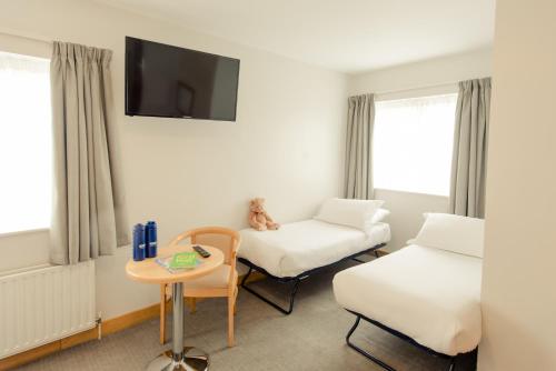 um quarto com uma cama, uma cadeira e uma mesa em Waterford Viking Hotel em Waterford