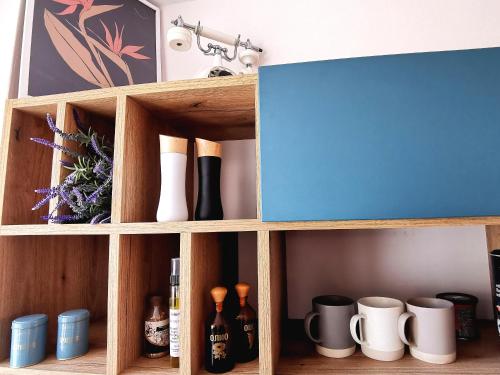 a wooden cabinet with bottles and mugs in it at Rare view in Plovdiv