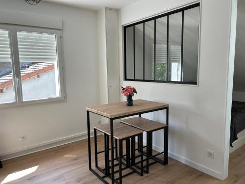 - une table avec deux tabourets dans une chambre avec une fenêtre dans l'établissement Appartement proche A43, proche gare de Bourgoin, à Domarin