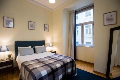 a bedroom with a bed and a large window at Ola Lisbon - Chiado 1 in Lisbon