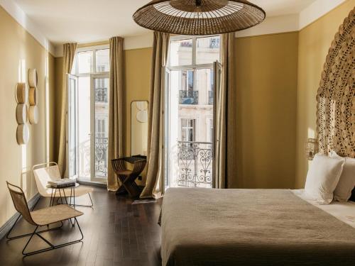 New Hotel Le Quai - Vieux Port في مارسيليا: غرفة نوم بسرير ونافذة كبيرة