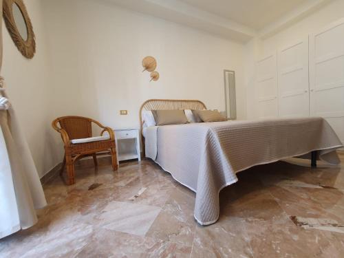 a bedroom with a bed and a chair at Posidonia B&B in Terrasini