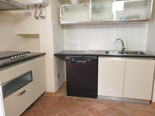 una pequeña cocina con fregadero y lavavajillas en La Veranda, en Marradi