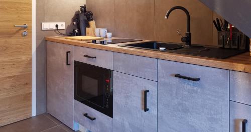 a kitchen with a sink and a microwave at Filder-Appartements in Filderstadt