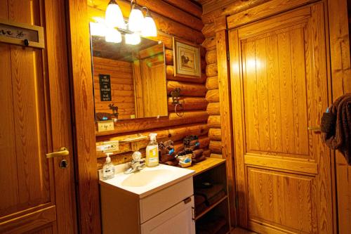 ein Badezimmer mit einem Waschbecken und einem Spiegel in einer Blockhütte in der Unterkunft Moose Lodge with Hot Tub in Sevierville