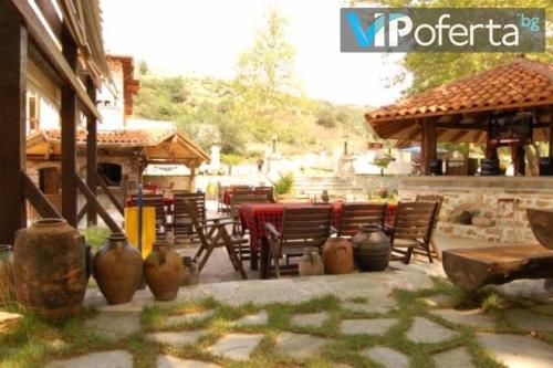 a patio with a table and chairs and a pavilion at Парк - Хотел Макензен in Melnik