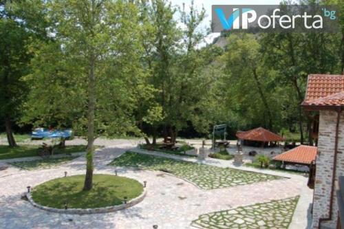 a park with a tree and a playground at Парк - Хотел Макензен in Melnik