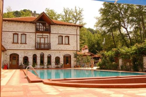 a house with a swimming pool in front of a building at Парк - Хотел Макензен in Melnik