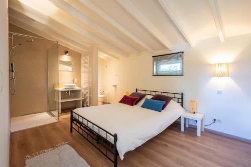 een slaapkamer met een groot bed en een douche bij House On The Green in Waregem
