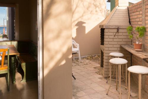 a patio with a table and stools in a kitchen at La Reserva en el Mar in Puerto Pirámides