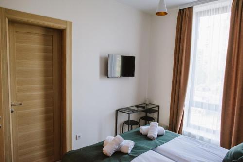 a bedroom with a bed with white towels on it at AVIOR Garni Hotel in Subotica