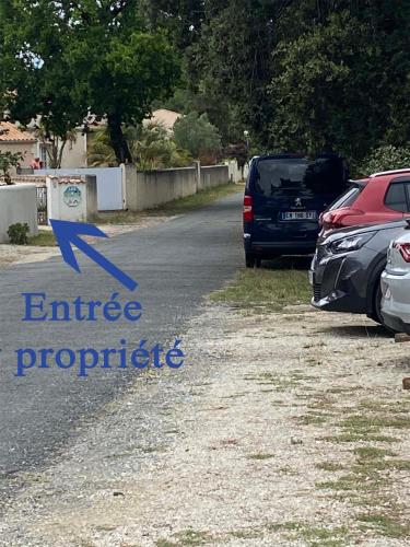 two cars parked on the side of a road at Villa des 4 saisons in Saint-Trojan-les-Bains