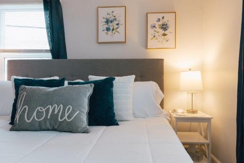 a bed with a pillow with home written on it at Villa Chic near Downtown Bristol King Bed in Bristol