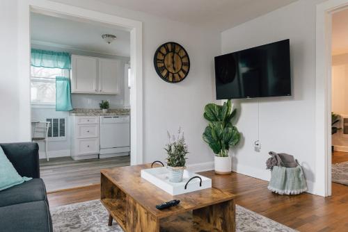 a living room with a table and a clock on the wall at Villa Chic near Downtown Bristol King Bed in Bristol