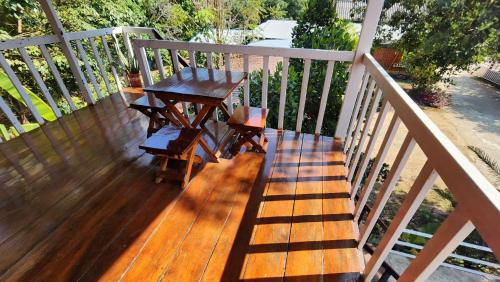 a wooden deck with a table and chairs on it at Bansuanphuhong Resort in Chiang Khan