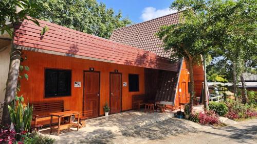 a building with tables and benches in front of it at Bansuanphuhong Resort in Chiang Khan