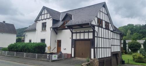 a black and white house with a garage at Ferienwohnung "Fernblick" Wolzhausen in Breidenbach
