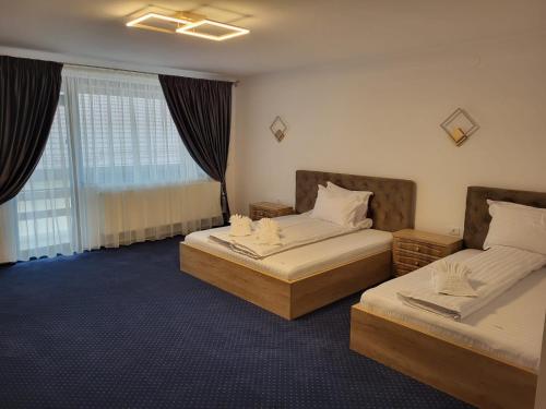 a hotel room with two beds and a window at Pensiunea Lara in Râşnov