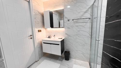 y baño blanco con lavabo y ducha. en BMB GROUP HÜRRİYET HOME en Bursa
