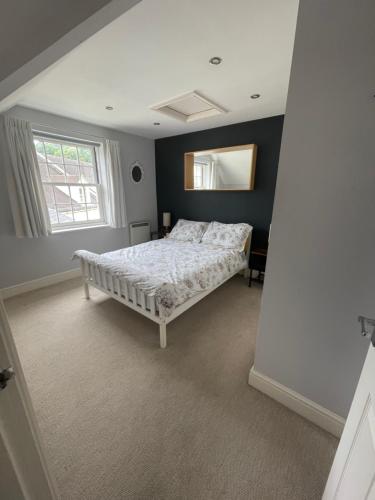 a bedroom with a bed and a mirror on the wall at Modern loft retreat in the heart of Nailsworth in Nailsworth