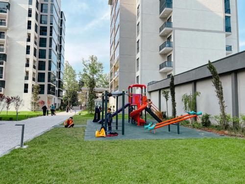 un parque infantil en un parque junto a un edificio en BMB GROUP HÜRRİYET HOME en Bursa