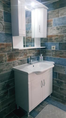 a bathroom with a white sink and a mirror at Dilbar Villa in Akbük