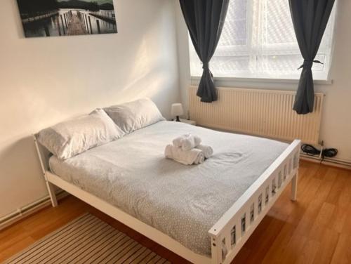 a bed with a stuffed animal on it in a bedroom at Beautiful Rooms close to Brick Lane in London