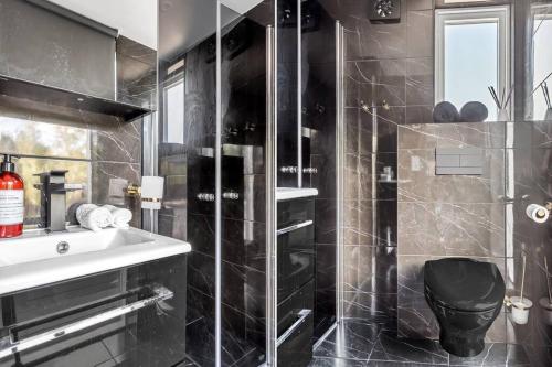 y baño con lavabo, ducha y aseo. en Newly built Luxurious Guest house en Åkersberga