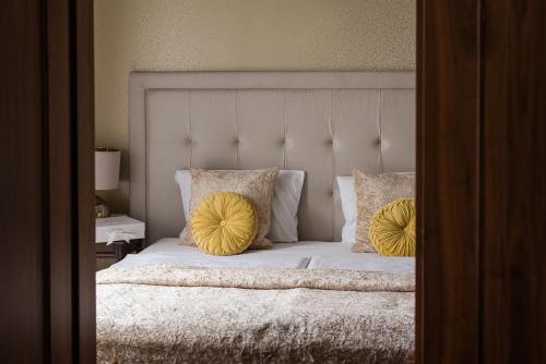 a bedroom with a bed with two yellow pillows at Rezydencja Luxury Hotel Bytom Piekary Śląskie in Piekary Śląskie