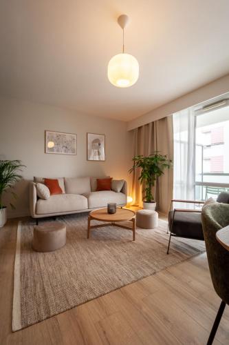 un salon avec un canapé et une table dans l'établissement La Brise 4* I T3 Centre Ville I Garage, à Annecy