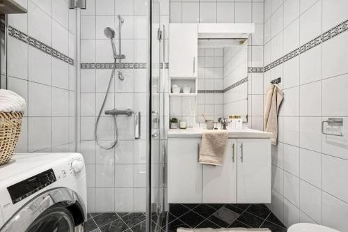 a bathroom with a shower and a washing machine at Luxurious Retreat in the Middle of City Center in Bergen