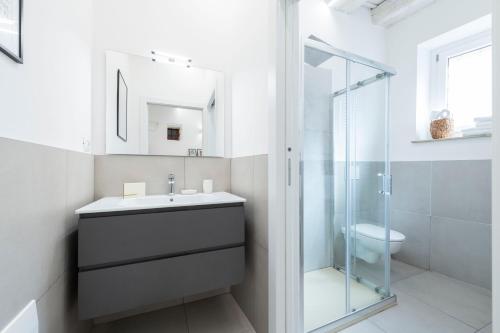 a bathroom with a sink and a glass shower at Casa di Sophia in Verona