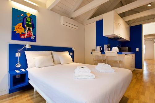 a bedroom with a large white bed with blue walls at Downtown Cosy Suite V in Porto