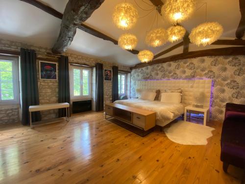 een slaapkamer met een groot bed in een kamer met houten vloeren bij Saint Palais sur mer Piscine in Breuillet