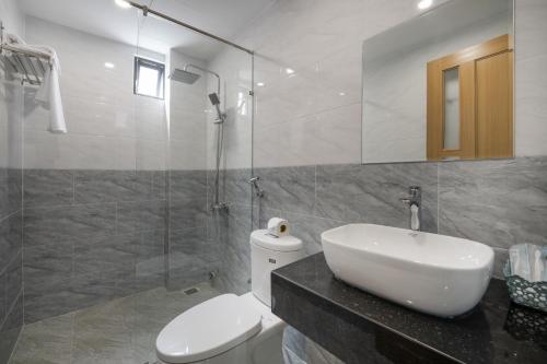 uma casa de banho com um WC, um lavatório e um chuveiro em Melody Hotel em Da Nang