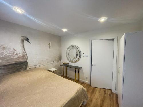 a bedroom with a bed and a picture of a bird on the wall at Dwa Żurawie - Głuszyn in Głuszyn