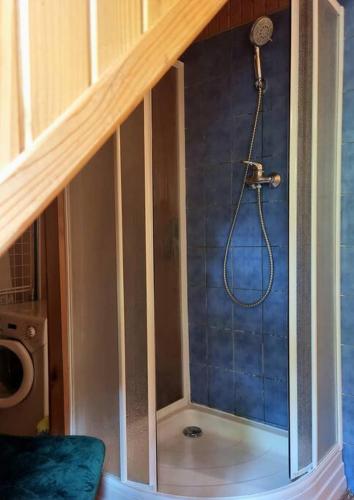 a shower in a bathroom with a blue wall at Apartmán RN in Banská Štiavnica