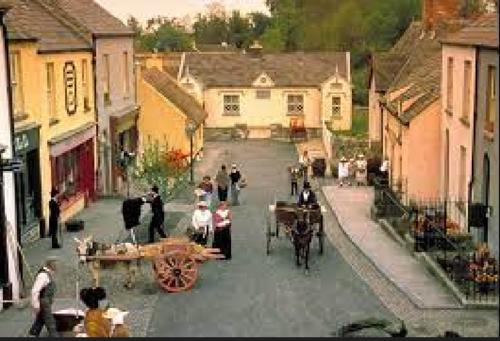 a group of people walking down a street at Bunratty Castle Gardens in Bunratty