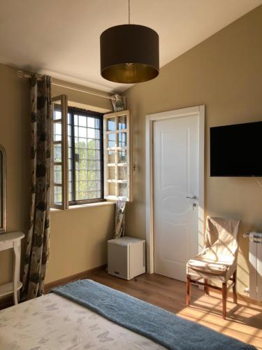 a bedroom with a bed and a chair and a television at Villa di Christian e Michelle in Rome