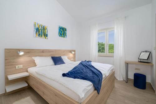a bedroom with a bed with a blue blanket on it at Villa Maja by IstriaLux in Orbanići