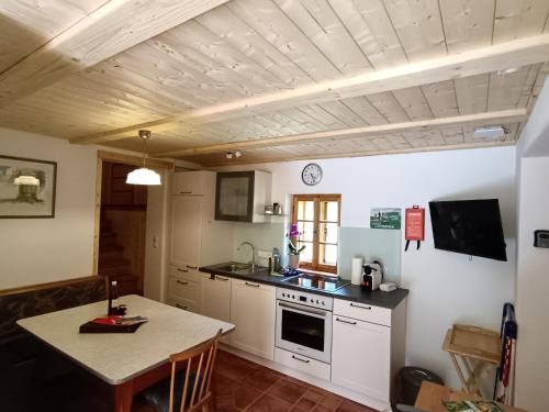 a kitchen with a table and a stove top oven at Ferienhaus Grabenhansl in Stubenberg