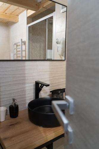 a bathroom with a black sink and a mirror at B&B Domus Magma in Pompei