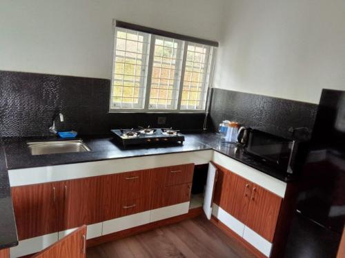 a kitchen with a sink and a counter top at Thekkekara Tourist Home Vagamon in Vagamon