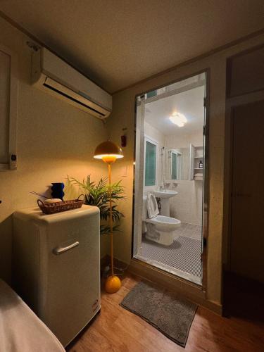 a bathroom with a shower with a toilet and a refrigerator at Jnineguesthouse in Seoul