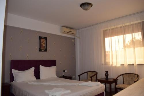 ein Schlafzimmer mit einem weißen Bett und einem Fenster in der Unterkunft Hotel Ibiza in Eforie Nord
