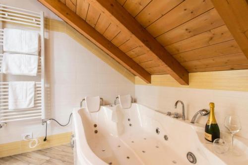 bañera blanca en una habitación con ventana en BHL SUITE Jacuzzi LEGNANO, en Legnano