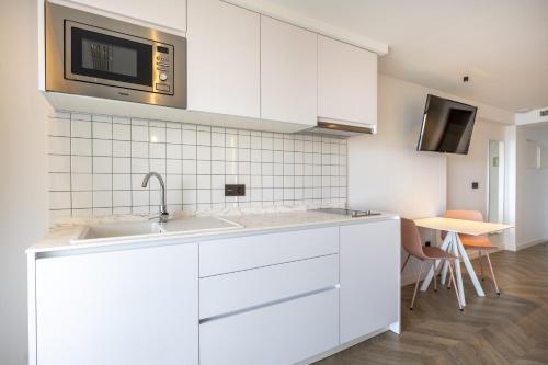 a white kitchen with a sink and a microwave at Climia Belroy 4 Sup in Benidorm