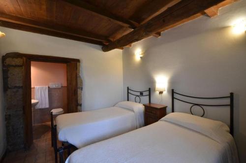 a bedroom with two beds and a bathroom at Agriturismo Buriano in Lubriano