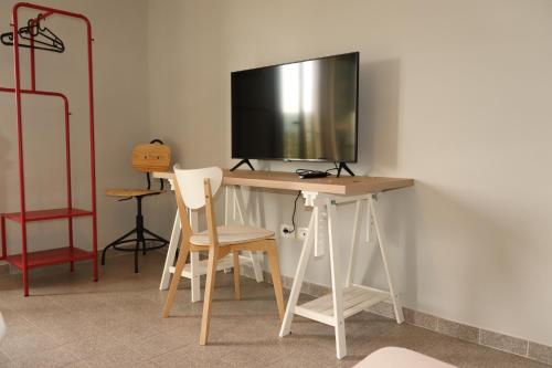 a desk with two chairs and a television on a wall at Azienda Agricola Sebastiani in Cittaducale