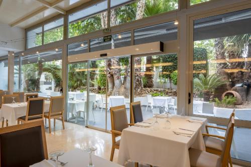 a restaurant with white tables and chairs and large windows at Climia Belroy 4 Sup in Benidorm